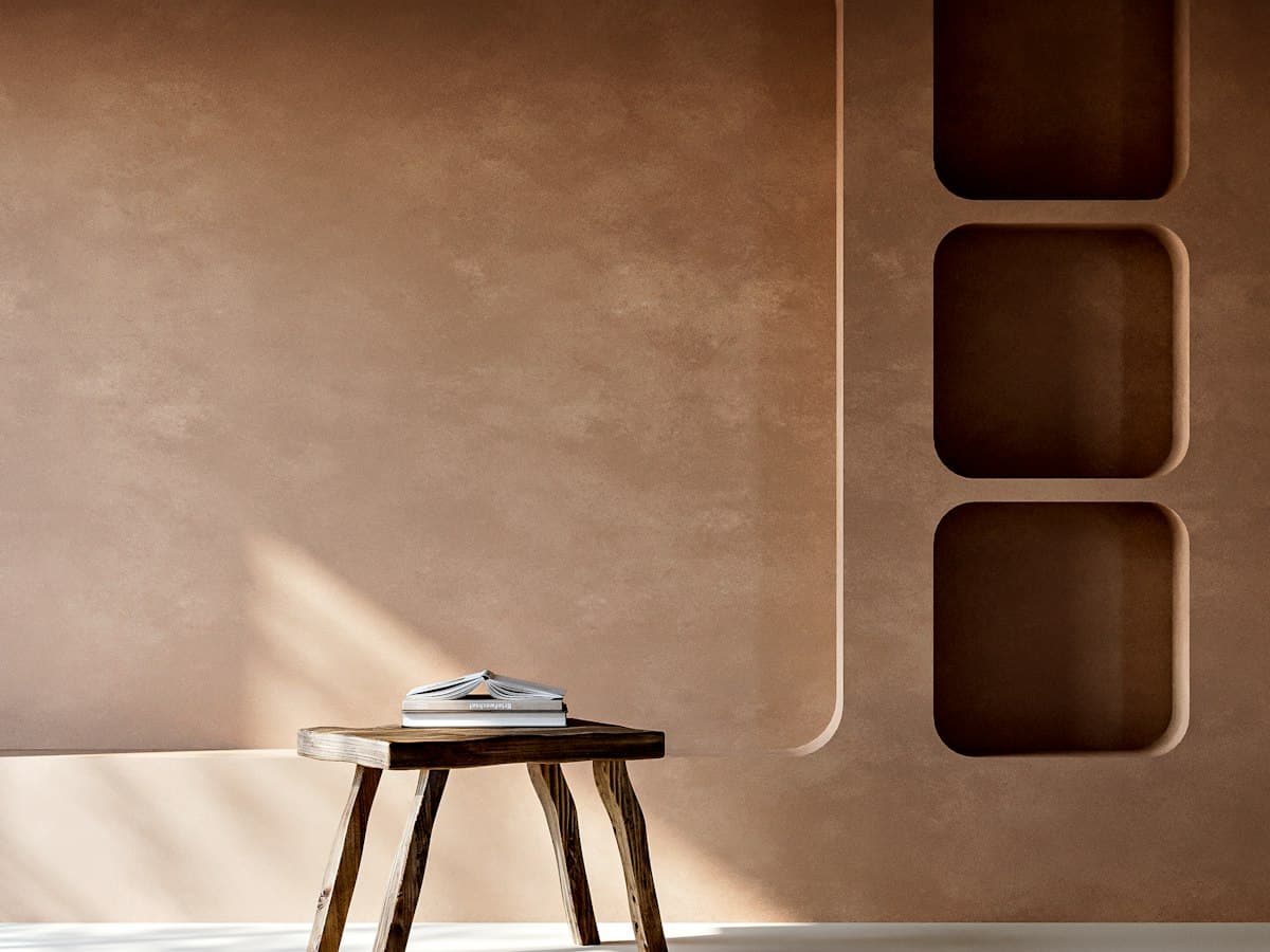 Earth-toned lime wall with built-in niches and a wooden stool