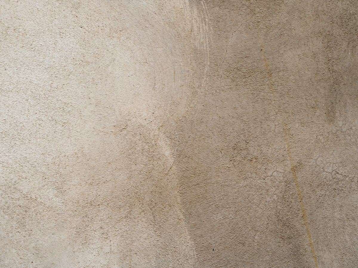 Beige lime plaster wall with a matte, stone-like texture