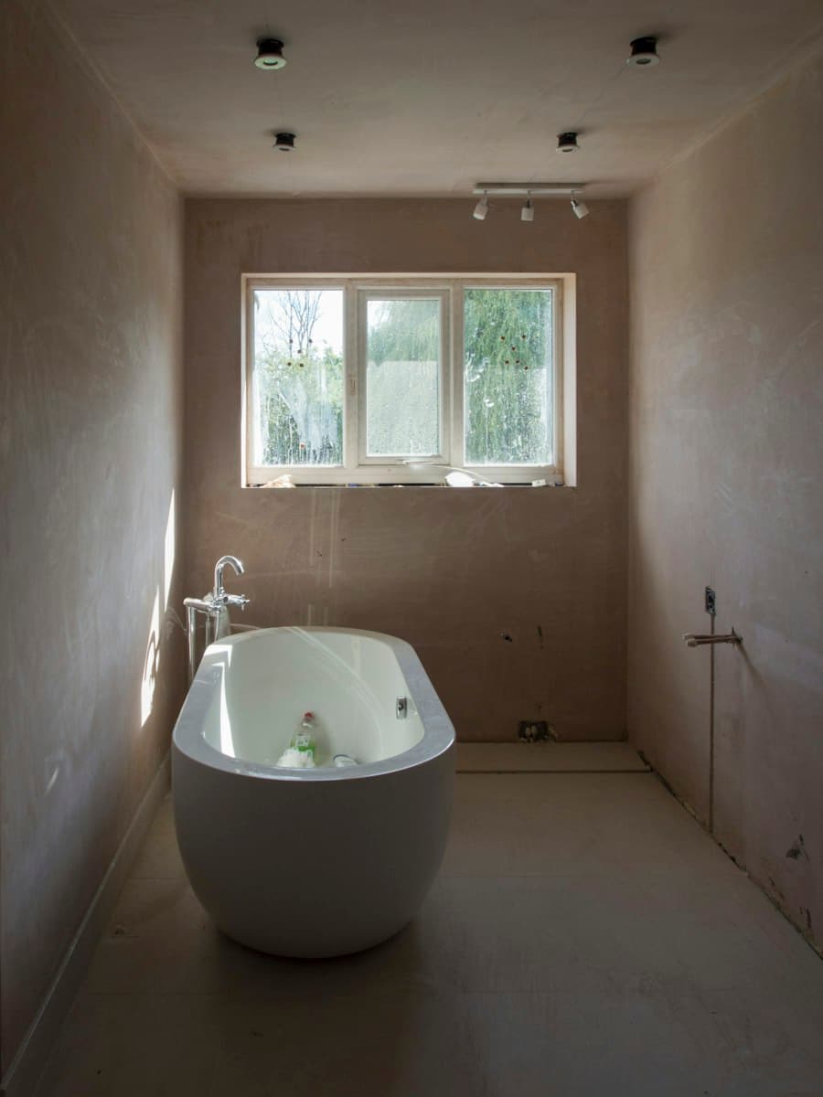 Plaster-walled bathroom with a freestanding tub